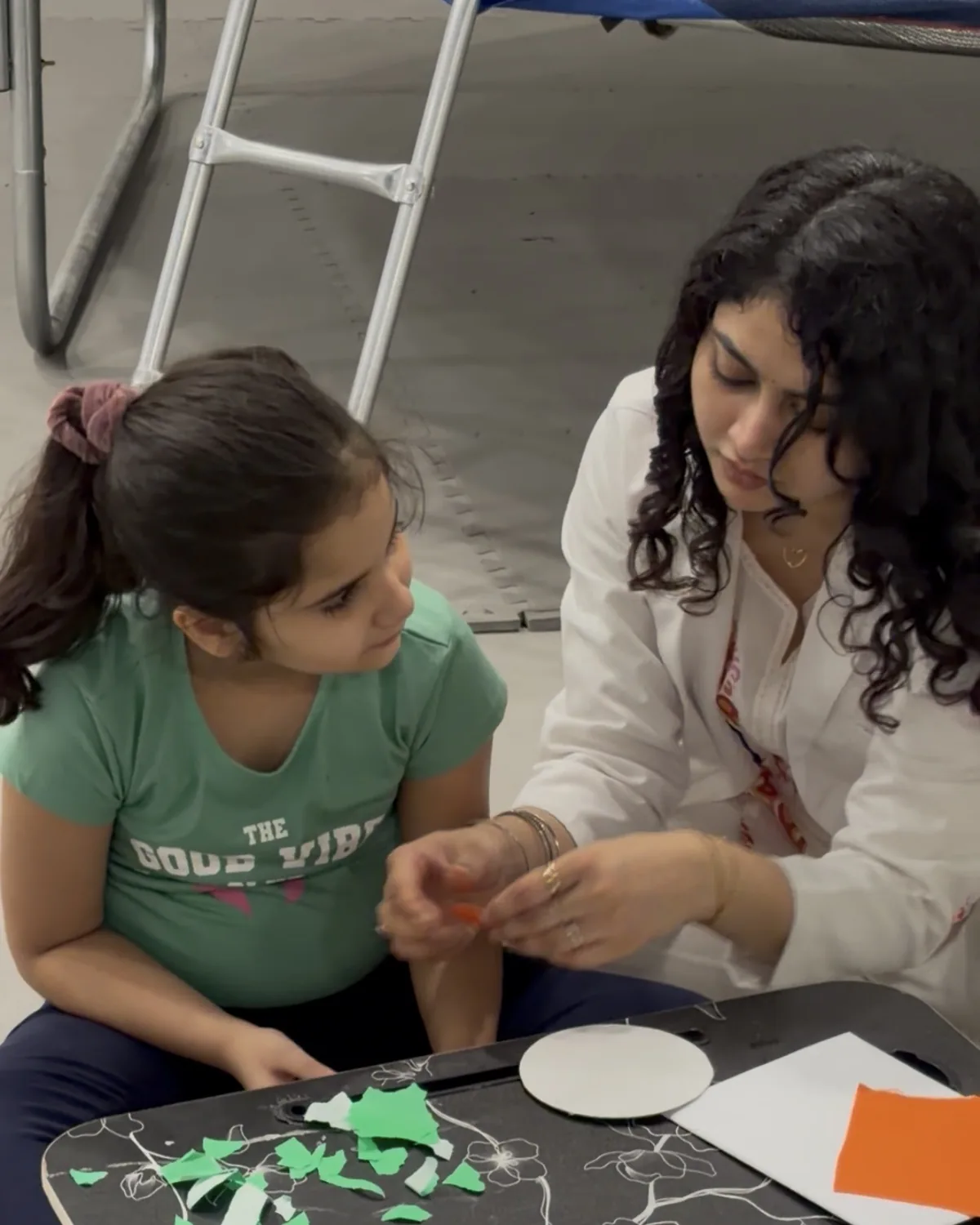 A therapist and a girl talking during a craft activity